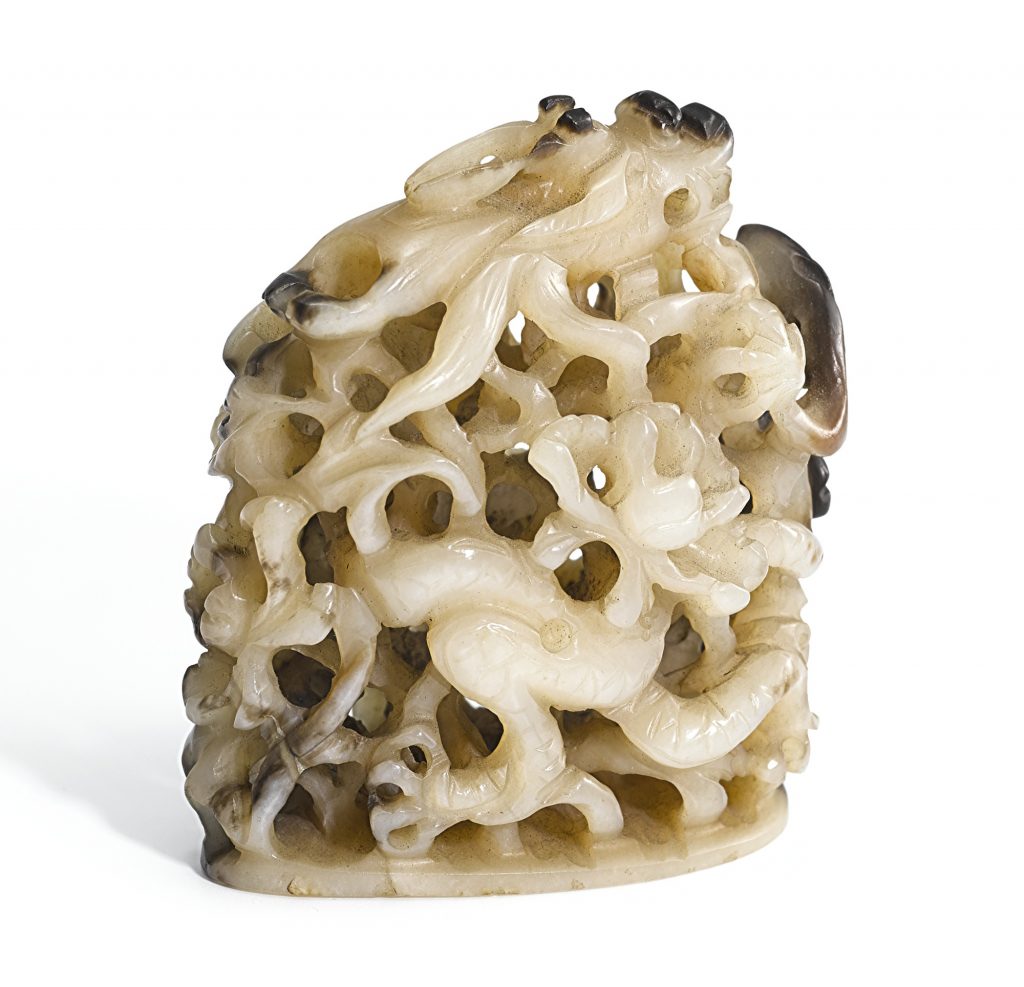 A WHITE AND BROWN JADE RETICULATED 'DRAGON' FINIAL
