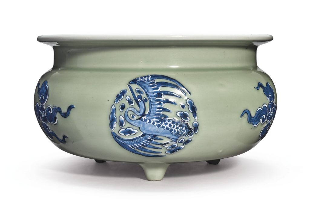 A CELADON-GROUND BLUE AND WHITE SLIP-DECORATED TRIPOD CENSER