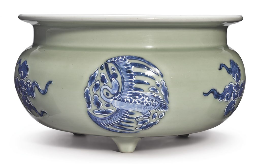 A CELADON-GROUND BLUE AND WHITE SLIP-DECORATED TRIPOD CENSER