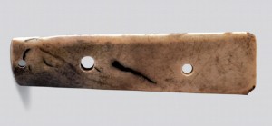 玉圭 新石器时代晚期 长21.7、宽5.7厘米 现藏于陕西历史博物馆 玉质青白色，有灰黄色沁。长条形扁平体，弧首平刃，上中下依次钻三孔，通体抛光，形制规整。