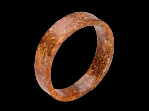 玉镯 良渚文化 直径6.8、厚1.6厘米 现藏于杭州历史博物馆 玉质受沁呈红褐色。呈不规则圆形，束腰，通体无纹，打磨光滑，切割面线条坚挺。为早年出土器物。