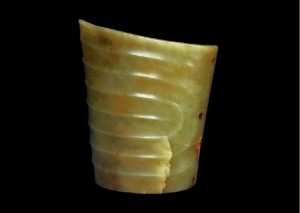 斜口筒形玉器 红山文化 高4.6、口径8.1厘米 现藏于辽宁省博物馆 玉质深绿色，杂有黑色点状杂质，有一道裂隙纵贯上下。器作扁圆筒形，上端外敞作斜口，下端略窄作平口，较红山文化遗址中常见的玉斜口筒形器稍矮，也可能是残断后经过改制。这类器型在出土时多发现于死者的头部，所以现在学者倾向于认为其功能是巫师用于沟通天地的法器。