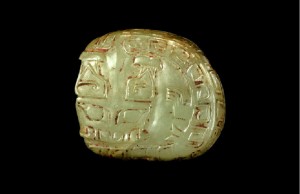 龙纹玉饰 商代 长3.5、宽4厘米 现藏于天津博物馆 玉质黄绿色。浅浮雕正视为一盘龙，瓶形角，一足，体饰回纹。